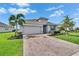 Attractive single-Gathering home with a well-manicured lawn, mature landscaping, and a brick driveway at 11785 Little River Way, Parrish, FL 34219