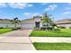 Well-maintained single-story home showcasing a brick driveway, green lawn, and mature landscaping at 11785 Little River Way, Parrish, FL 34219
