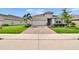 Beautiful one-story home boasts mature landscaping, a brick driveway, and an attached two-car garage at 11785 Little River Way, Parrish, FL 34219