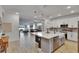Bright, open kitchen featuring white cabinets, stainless appliances, and a large island with pendant lighting at 11785 Little River Way, Parrish, FL 34219