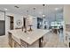 Spacious kitchen featuring an island with a sink and ample seating, flowing into the dining and living areas at 11785 Little River Way, Parrish, FL 34219