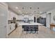 Open-concept kitchen featuring stainless steel appliances, white cabinets, and an island with bar stools at 11785 Little River Way, Parrish, FL 34219