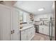 Well-lit kitchen featuring white cabinetry, stainless steel appliances, and a granite countertop at 11809 Raintree Lake Ln # A, Tampa, FL 33617