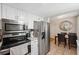 Well-lit kitchen featuring tile floors, stainless steel appliances, and white cabinetry at 11809 Raintree Lake Ln # A, Tampa, FL 33617