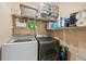 Well-organized laundry room featuring washer, dryer, shelving, and ample storage space at 11809 Raintree Lake Ln # A, Tampa, FL 33617