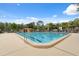 Bright swimming pool with clear blue water, lounge chairs, and a bathhouse under a partly cloudy sky at 11809 Raintree Lake Ln # A, Tampa, FL 33617