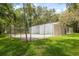 Fenced racquetball court surrounded by green grass, mature shade trees, and an open space at 11809 Raintree Lake Ln # A, Tampa, FL 33617