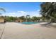 Community swimming pool with deck chairs, and pool house with lush landscaping in the background at 11809 Raintree Lake Ln # A, Tampa, FL 33617