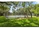 Outdoor tennis court behind chain link fence surrounded by mature shade trees at 11809 Raintree Lake Ln # A, Tampa, FL 33617