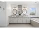 Bright bathroom featuring a double vanity with granite countertop and decorative mirrors at 1191 Darlington Oak Ne Dr, St Petersburg, FL 33703