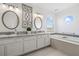 Bright bathroom featuring double sinks, granite countertops, and a luxurious soaking tub at 1191 Darlington Oak Ne Dr, St Petersburg, FL 33703