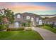 Stunning two-story home with meticulously maintained lawn, mature trees, colorful flower beds, and a winding driveway at 1191 Darlington Oak Ne Dr, St Petersburg, FL 33703