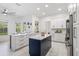 Bright and spacious kitchen featuring stainless steel appliances, white cabinetry, and a dark blue island at 1191 Darlington Oak Ne Dr, St Petersburg, FL 33703
