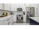 Modern kitchen with stainless steel appliances, white cabinetry, and marble-like flooring at 1191 Darlington Oak Ne Dr, St Petersburg, FL 33703