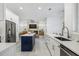 Bright, open kitchen with white cabinets, stainless steel appliances, and a contrasting blue island at 1191 Darlington Oak Ne Dr, St Petersburg, FL 33703