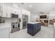 Bright kitchen with stainless steel appliances, quartz countertops, custom island with seating, and fireplace at 1191 Darlington Oak Ne Dr, St Petersburg, FL 33703
