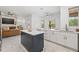 Spacious kitchen featuring white cabinets, stainless steel appliances, and a contrasting blue island at 1191 Darlington Oak Ne Dr, St Petersburg, FL 33703