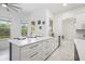 Bright kitchen featuring white cabinets, an island with seating, and views of the outdoors at 1191 Darlington Oak Ne Dr, St Petersburg, FL 33703