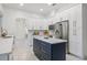 Spacious kitchen with white cabinets, stainless steel appliances, and a dark blue island at 1191 Darlington Oak Ne Dr, St Petersburg, FL 33703