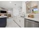 Modern kitchen with a view into the living area, featuring stainless steel appliances and white cabinets at 1191 Darlington Oak Ne Dr, St Petersburg, FL 33703