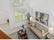 Living room boasts soaring windows, a neutral sofa, and artwork adorning white walls and neutral tile at 1191 Darlington Oak Ne Dr, St Petersburg, FL 33703