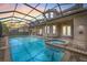 Screened pool with connected hot tub, spacious patio, outdoor bar and partial view of the two story home at 1191 Darlington Oak Ne Dr, St Petersburg, FL 33703