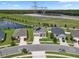 Aerial view of the neighborhood featuring modern homes, green spaces, and a nearby lake at 12481 Aston Dr, Hudson, FL 34669