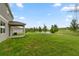 Expansive backyard featuring lush green grass and a tranquil pond view on a sunny day at 12481 Aston Dr, Hudson, FL 34669