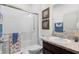 Bathroom showcasing a walk-in shower, granite countertop vanity, and decorative framed artwork at 12481 Aston Dr, Hudson, FL 34669