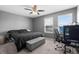 Cozy gray bedroom featuring a ceiling fan, natural light, and a comfortable bed at 12481 Aston Dr, Hudson, FL 34669