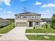 Charming two-story home with a well-maintained lawn, a two-car garage, and gray siding under a sunny sky at 12481 Aston Dr, Hudson, FL 34669