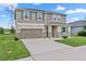 Two-story home featuring a two-car garage, a well-manicured lawn and landscaping, and neutral-toned siding at 12481 Aston Dr, Hudson, FL 34669