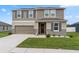Two-story home with a two-car garage, neutral siding, and a landscaped front yard at 12481 Aston Dr, Hudson, FL 34669