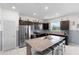 Well-lit kitchen features stainless appliances, granite countertops, oversized island and dark cabinets at 12481 Aston Dr, Hudson, FL 34669