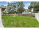 Lush backyard featuring a large grassy area, a privacy fence, and a cozy fire pit at 1349 Tyrone N Blvd, St Petersburg, FL 33710