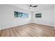 Cozy bedroom with wood-look flooring, natural light from large windows and a ceiling fan at 1349 Tyrone N Blvd, St Petersburg, FL 33710