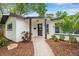 Charming covered entryway features a stylish front door, lush landscaping and a welcoming path at 1349 Tyrone N Blvd, St Petersburg, FL 33710