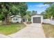 Charming single story home with a well-manicured lawn, mature trees, and a driveway leading to the garage at 1349 Tyrone N Blvd, St Petersburg, FL 33710