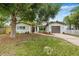 Single story home boasts a fresh exterior, manicured lawn, and a driveway leading to an attached garage at 1349 Tyrone N Blvd, St Petersburg, FL 33710
