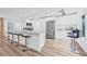 Bright kitchen boasts white cabinetry, stainless steel appliances, a large island with seating and wood style flooring at 1349 Tyrone N Blvd, St Petersburg, FL 33710