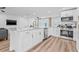 Modern kitchen featuring stainless steel appliances, a central island with bar seating, and wood-look flooring at 1349 Tyrone N Blvd, St Petersburg, FL 33710