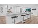 Modern kitchen features a large island with seating, stainless steel appliances, white cabinets and wood-look flooring at 1349 Tyrone N Blvd, St Petersburg, FL 33710