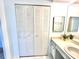 Bathroom featuring a double door closet, vanity, mirror, and sink at 13926 Mission Oaks Blvd, Seminole, FL 33776