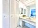 Bathroom featuring a double door closet, vanity, mirror, sink and bright lights at 13926 Mission Oaks Blvd, Seminole, FL 33776