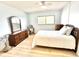 Light-filled bedroom with wood-look floors, a ceiling fan, and matching dressers and a comfortable bed at 13926 Mission Oaks Blvd, Seminole, FL 33776