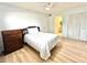Simple bedroom featuring wood-look flooring, a ceiling fan, and a double door closet leading to bathroom at 13926 Mission Oaks Blvd, Seminole, FL 33776