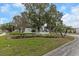Community entrance sign surrounded by beautiful landscaping and mature trees at 13926 Mission Oaks Blvd, Seminole, FL 33776