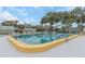 Large community pool surrounded by lounge chairs and mature trees at 13926 Mission Oaks Blvd, Seminole, FL 33776