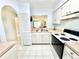 Practical kitchen design with stainless steel sink, tile floors, and adjacent dining area at 13926 Mission Oaks Blvd, Seminole, FL 33776