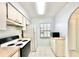 Bright kitchen with a window, classic appliances and tile flooring offers a clean, simple design at 13926 Mission Oaks Blvd, Seminole, FL 33776
